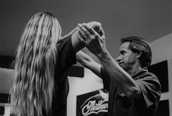 Instructor teaching young archer proper form