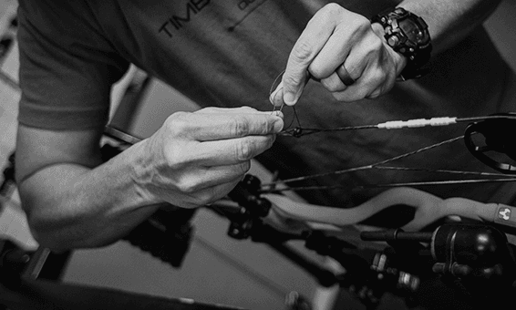 Expert technician working on compound bow string